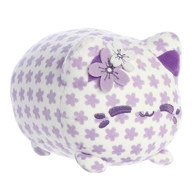 A purple and white Pusheen plush cat with a flower on its head.