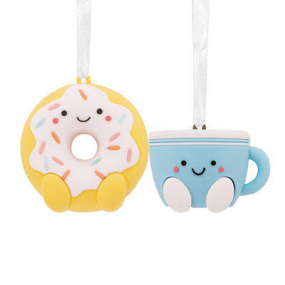 Donut and coffee Christmas ornaments. The donut is white with pink frosting and sprinkles. The coffee cup is red with white snowflakes.