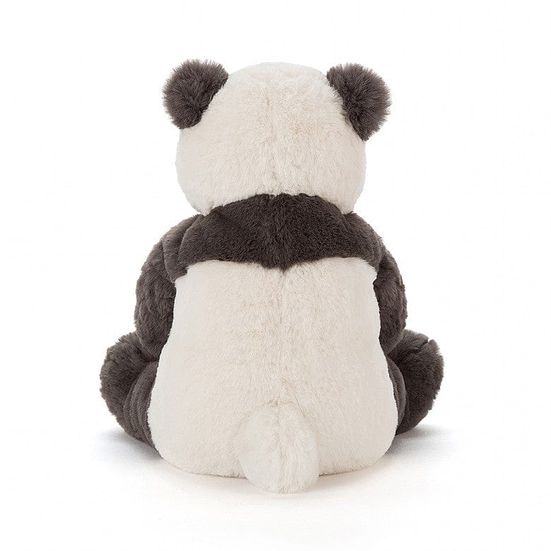 Stuffed panda bear sitting on a white surface.