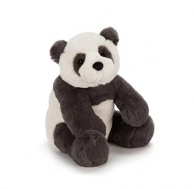 Stuffed panda bear sitting on a white surface.