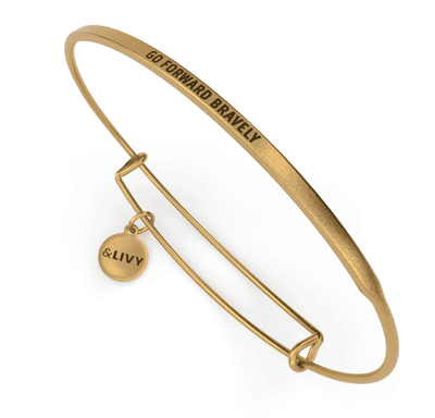Gold bangle bracelet with a round charm featuring the message “GO FORWARD BRAVELY”. The &Livy logo is engraved on the charm.