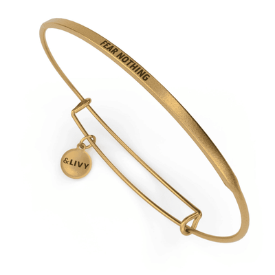 Gold bangle bracelet with the inspirational message “FEAR NOTHING” engraved on it