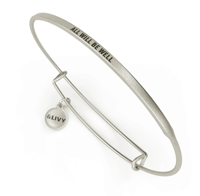 Silver bangle bracelet with the words "all will be well" engraved on it. The lettering is cursive. 