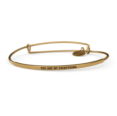 Gold bangle bracelet with the words "You are my everything" engraved on it.