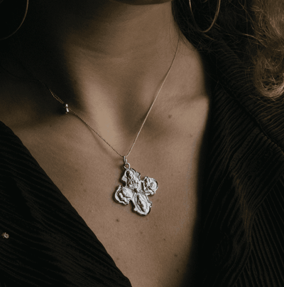 a small silver necklace with a four-way cross pendant.