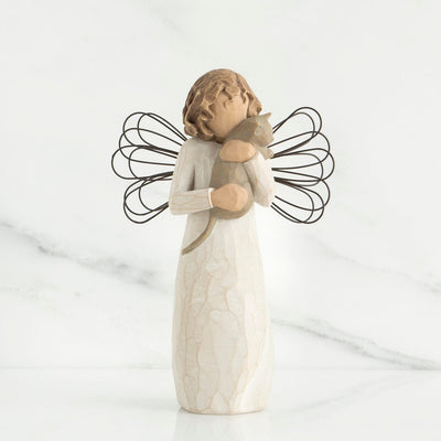 With affection, Willow Tree stands with a standing angel in a cream dress with wire wings, holding a gray cat in her arms.