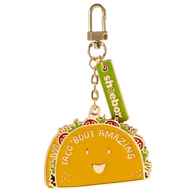 Hallmark taco keychain with smiling yellow taco charm and “Taco 'Bout Amazing” message in white.