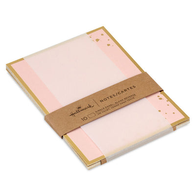 Pink flat note cards with gold foil frame and splatter dot accents, bundled in a kraft wrap.
