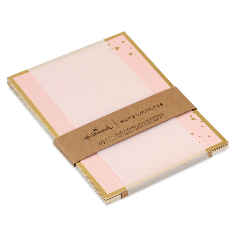 Pink flat note cards with gold foil frame and splatter dot accents, bundled in a kraft wrap.
