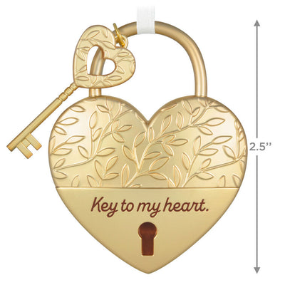 Gold metal heart ornament with leaf-vine design and key, engraved with “Key to my heart” — a romantic gift for newlyweds or partners.