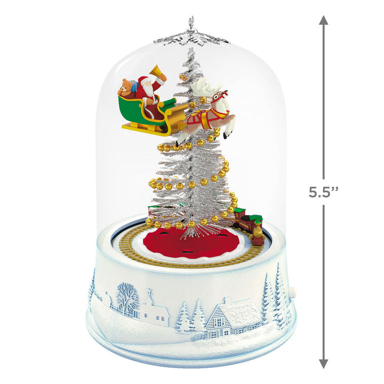 Santa sleigh and toy train under glass dome with lights and motion on snowy village base