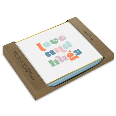 Pastel mod-style “Love and Hugs” blank note cards with gold foil frame on ivory paper, in kraft box.
