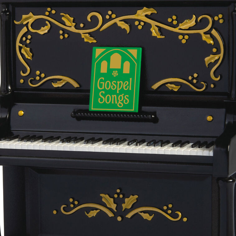 Upright Christmas piano ornament with gold holly accents, tinsel garland, and musical “I’ll Fly Away” gospel choir performa
