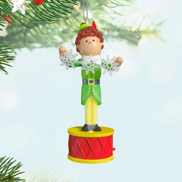 Buddy the Elf ornament with light and sound, standing on red base in green costume with snowflakes, inspired by the movie “Elf”