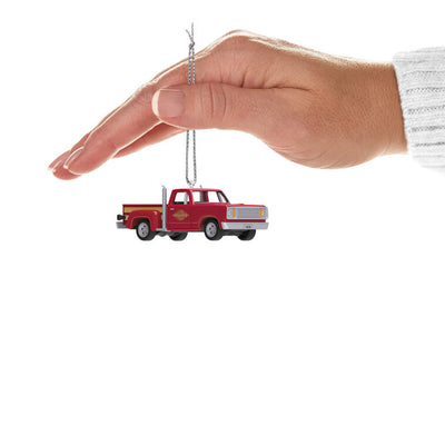 Miniature 1978 Dodge Li’l Red Express Christmas ornament in red and yellow with chrome stacks and turning wheels.