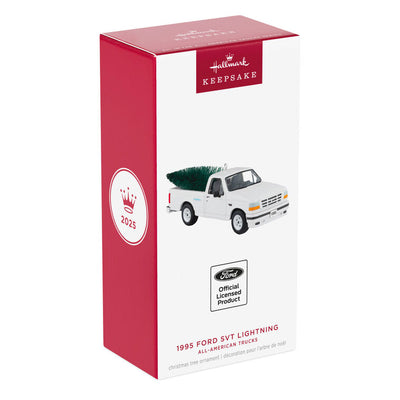 White 1995 Ford SVT Lightning truck ornament with turning wheels and a green bottlebrush Christmas tree in the truck bed.