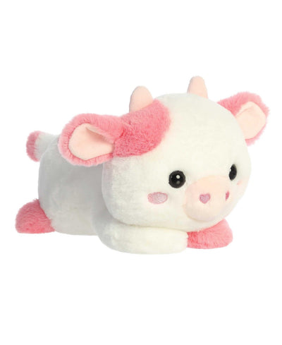 Katelyn Cow plush by Aurora in white and pink, lying belly-down with sparkling eyes and a heart-shaped nose for Valentine's Day.