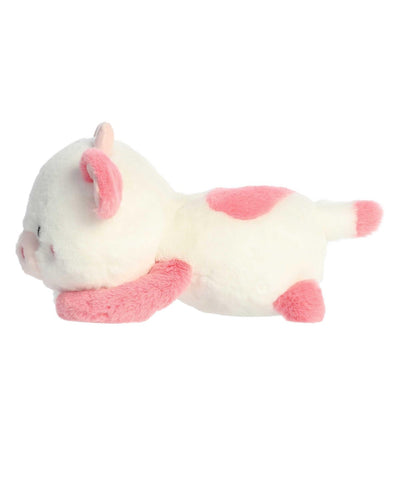 Katelyn Cow plush by Aurora in white and pink, lying belly-down with sparkling eyes and a heart-shaped nose for Valentine's Day.