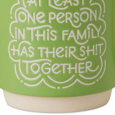 Bright green ceramic mug with white lettering that reads “At least one person in this family has their sh!t together