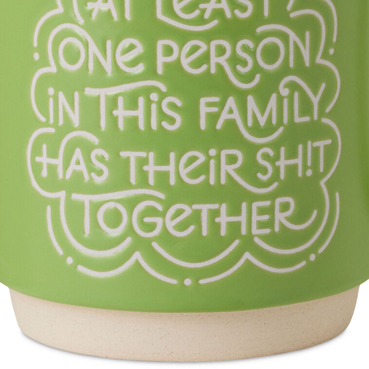 Bright green ceramic mug with white lettering that reads “At least one person in this family has their sh!t together