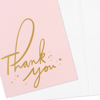 Pink thank-you cards with gold foil script and looped lettering, featuring delicate gold flecks.
