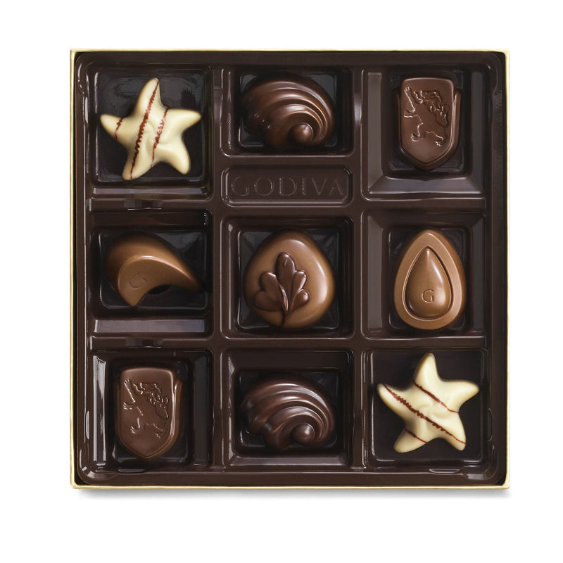 A 9-piece Godiva chocolate gift box in gold with ribbon, featuring assorted milk, dark, and white chocolates in rich, creamy, and crunchy flavors.

