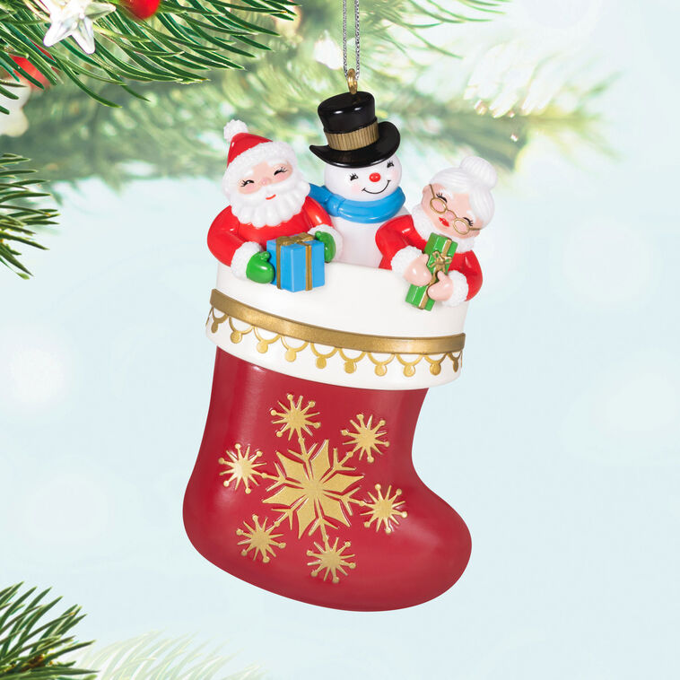 Hallmark Keepsake Stocking Stuffers ornament—red and white stocking with gold snowflakes, Santa, Mrs. Claus, and snowman in vintage style
