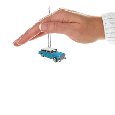 Miniature 1955 Chevrolet Nomad Wagon Christmas ornament in blue and white, featuring vintage styling, turning wheels, and silver accents.