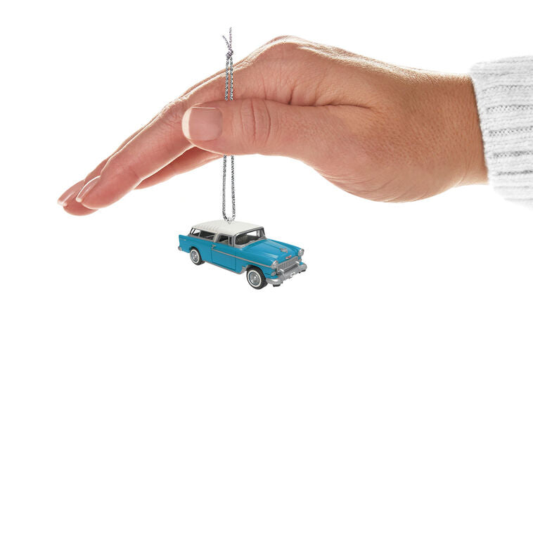 Miniature 1955 Chevrolet Nomad Wagon Christmas ornament in blue and white, featuring vintage styling, turning wheels, and silver accents.