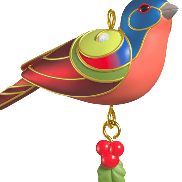 Painted Bunting miniature Christmas tree ornament with colorful feathers, metallic gold trim, and dangling holly berry charm
