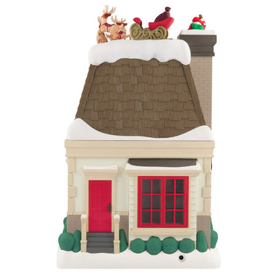Christmas decoration showing Santa dropping down a chimney with lights, motion, and music from Up on the Housetop

