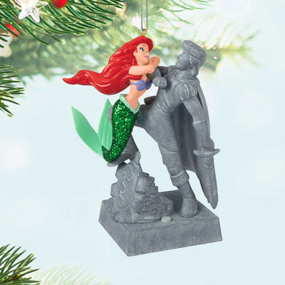 Ariel Christmas ornament gazing at Prince Eric's stone statue, tail curled behind her, from Disney's The Little Mermaid