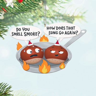 Funny Christmas ornament with two chestnuts roasting in a flaming skillet.

