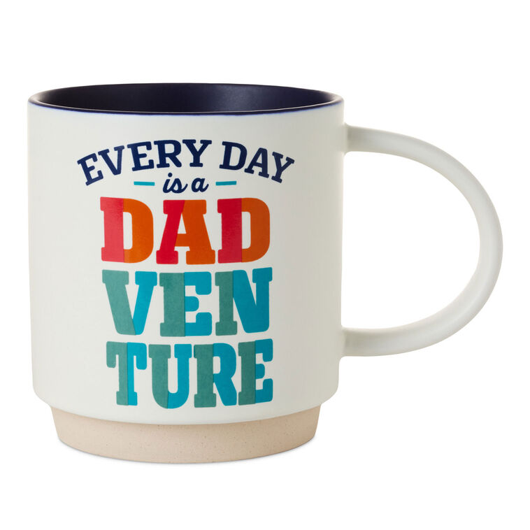 White ceramic mug with colorful "Every day is a Dadventure" lettering, oversized handle, and recessed base for stacking
