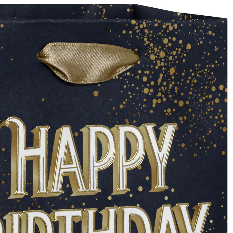 Small Hallmark gift bag with “Happy Birthday” in bold white and gold foil lettering on a navy blue background with gold splatter detail.