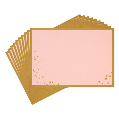 Pink flat note cards with gold foil frame and splatter dot accents, bundled in a kraft wrap.
