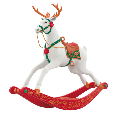 White reindeer Christmas ornament with bronze antlers and hooves, red flower accents, green bridle, on rocking stand

