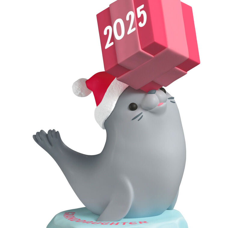 2025 Christmas ornament with gray seal in Santa hat on iceberg, balancing pink present on nose, festive design

