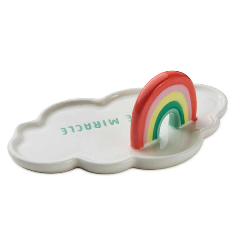 Ceramic cloud-shaped figurine with colorful rainbow arch and “Little Miracle” message in blue lettering.