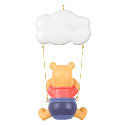 Winnie the Pooh Christmas ornament swinging under a "Baby’s 1st Christmas 2025" cloud with hunny pot and bee accents
