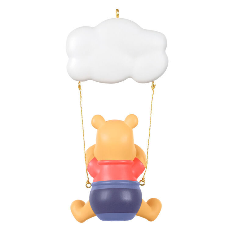 Winnie the Pooh Christmas ornament swinging under a "Baby’s 1st Christmas 2025" cloud with hunny pot and bee accents