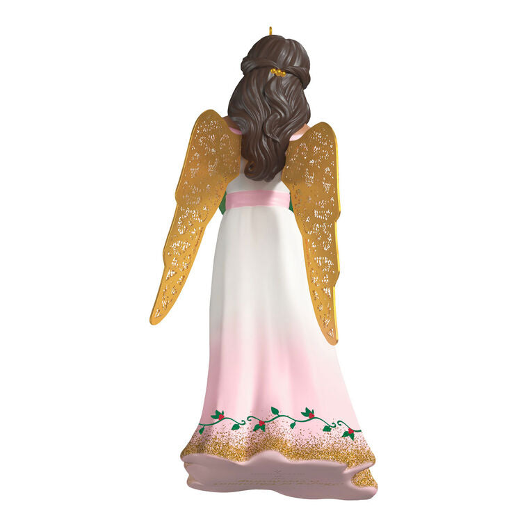 Hallmark Keepsake ornament of angel in pink and white gown with holly vines, holding a green wreath, gold metal wings, glitter accents