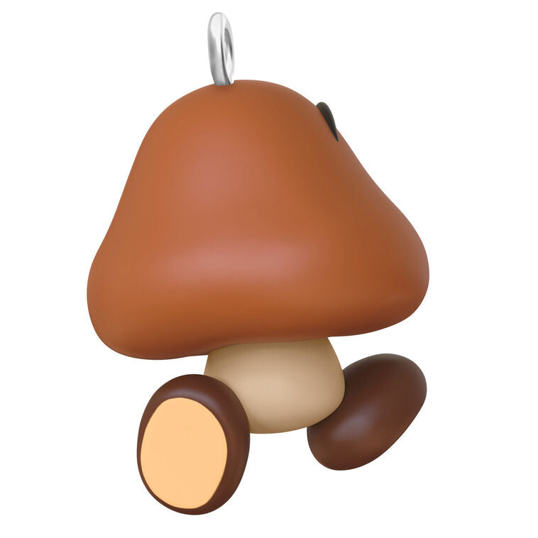 Hallmark Keepsake Mini Nintendo Super Mario Goomba ornament—brown mushroom-like enemy with sharp teeth, large eyes, oval feet, and angry eyebrows
