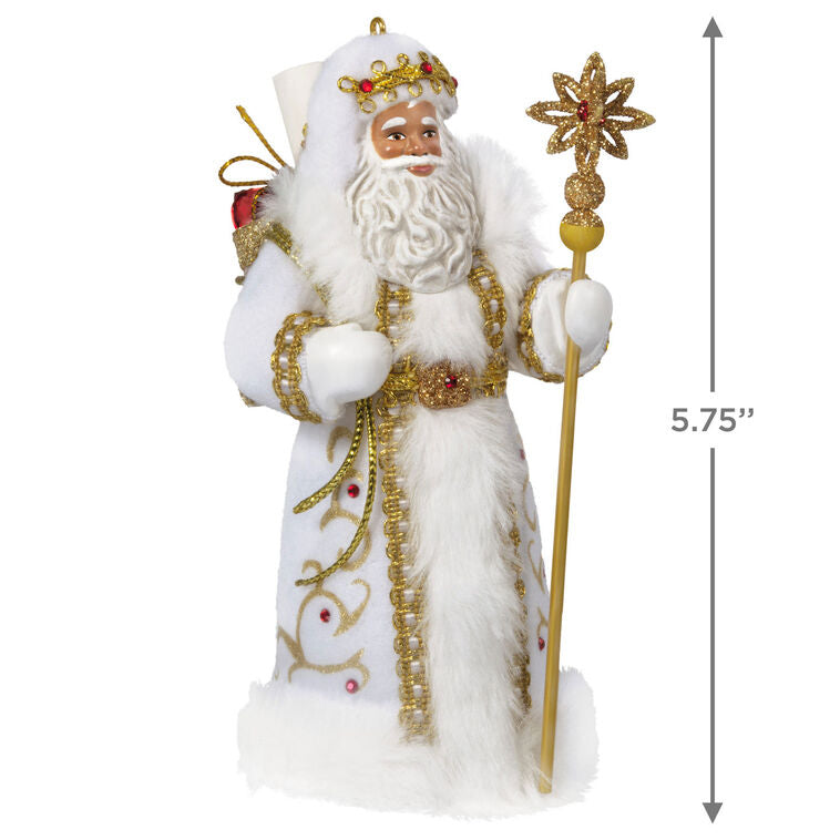 Black Father Christmas ornament in white coat with gold staff, faux-fur trim, and red gem accents.

