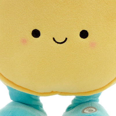 Round yellow smiley face plush toy with blue arms and legs, dancing and singing 'Happy' by Pharrell Williams when activated.
