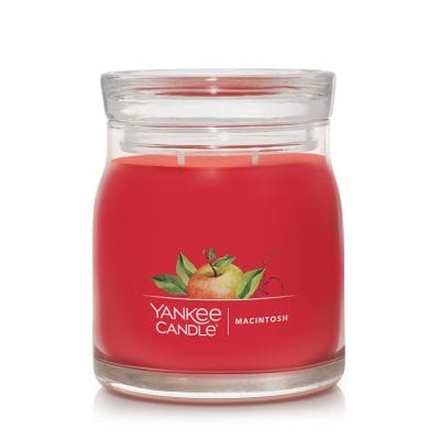 A 13 oz Yankee Candle Macintosh Medium Jar Candle with red wax and a silver lid, featuring crisp apple scent.