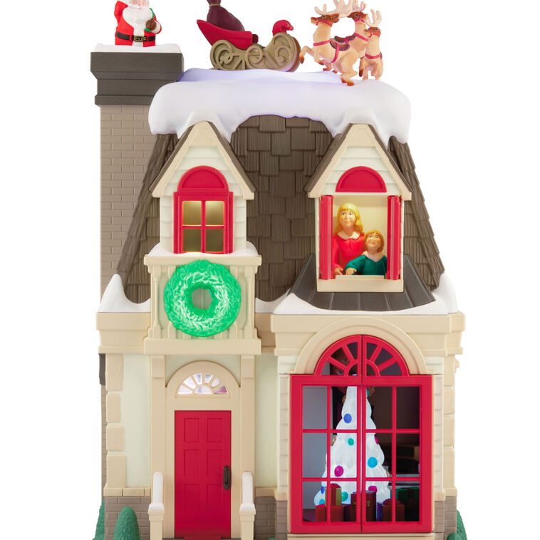 Christmas decoration showing Santa dropping down a chimney with lights, motion, and music from Up on the Housetop

