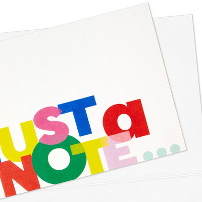 White note cards with playful block-style multicolor “Just a Note” lettering, bundled in kraft paper wrap.
