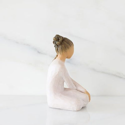 Willow Tree Serenity figurine, seated woman in cream dress with arms crossed in a calm, reflective pose.