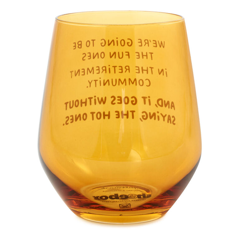 Amber-tinted stemless wine glass with white text: “We&